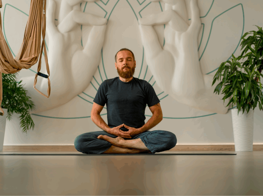 A man sitting on the floor while meditating.